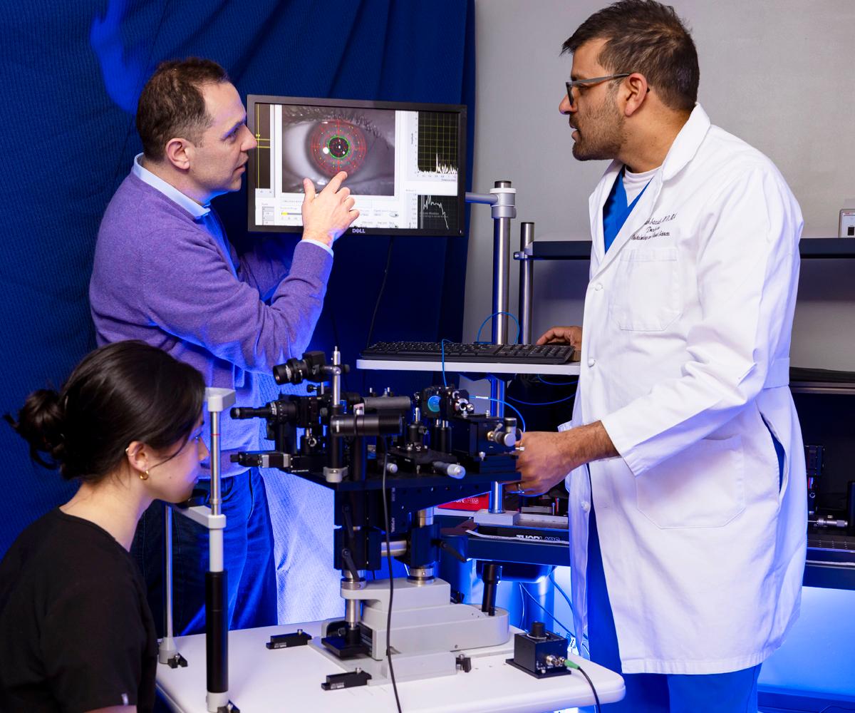 University of Maryland researchers stand in a lab looking at a screen.