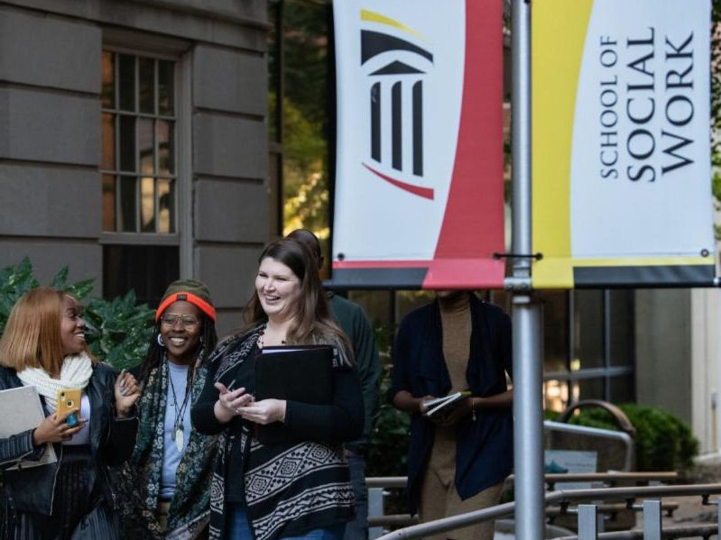 UMB community members walk by the School of Social Work building