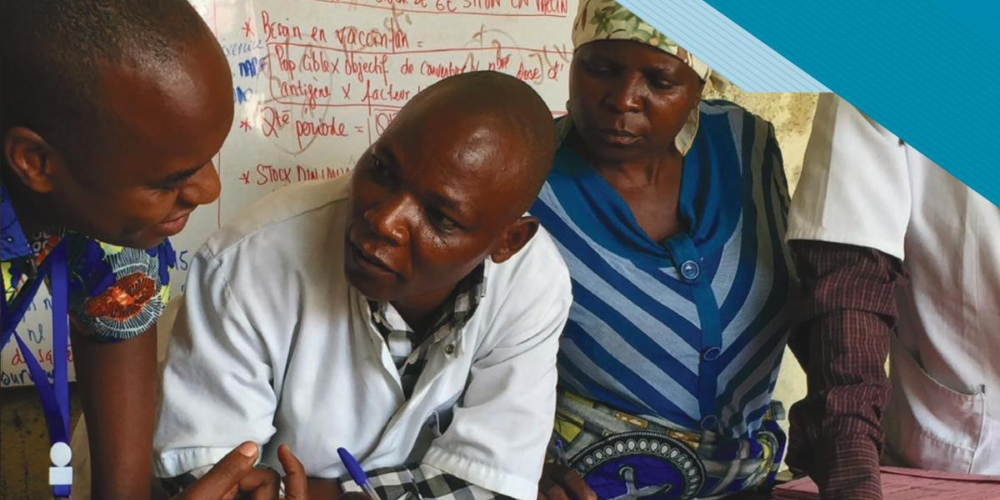 People lean over a table with documents