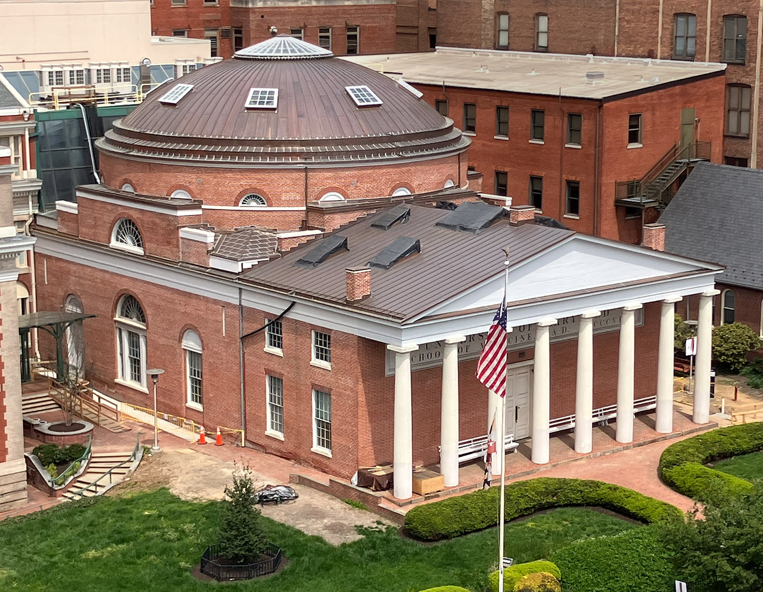 photo of Davidge Hall building with lawn, flag and surrounding Baltimore neighborhood