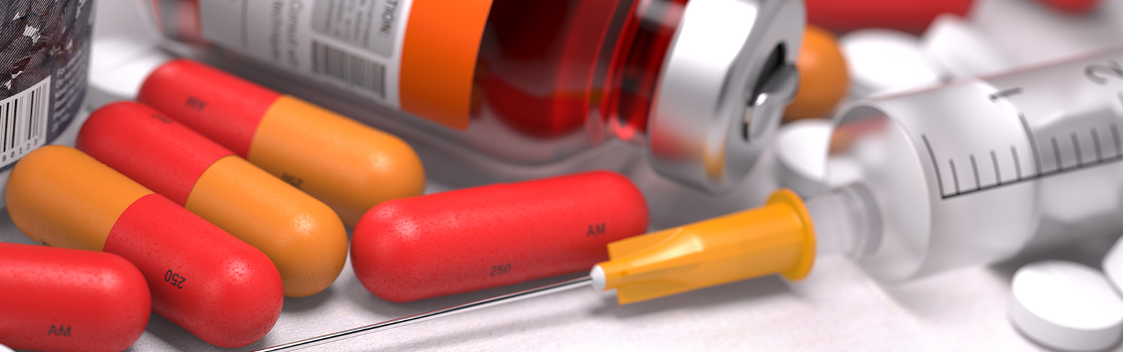 Image of a pills and syringe with a liquid bottle of medicine.