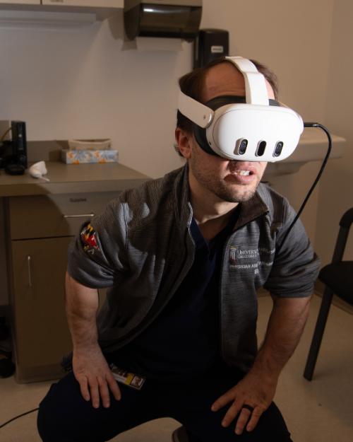 Benjamin Bromley-Coolidge, who is pursuing a master's degree in UMB’s Physician Assistant Program, tests out virtual reality goggles during a simulation training