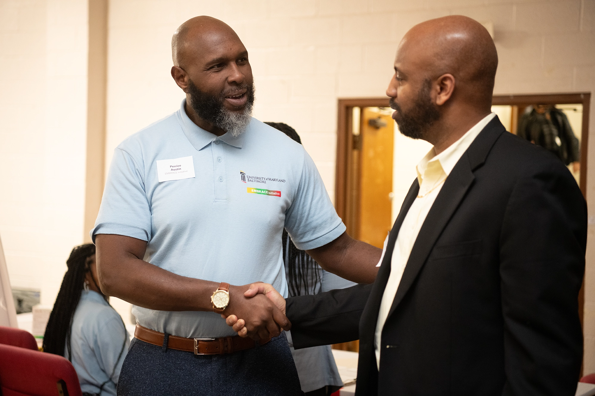 An EMBRACE staff member shaking hands with a community organizer