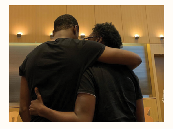 Two young men comforting and supporting each other