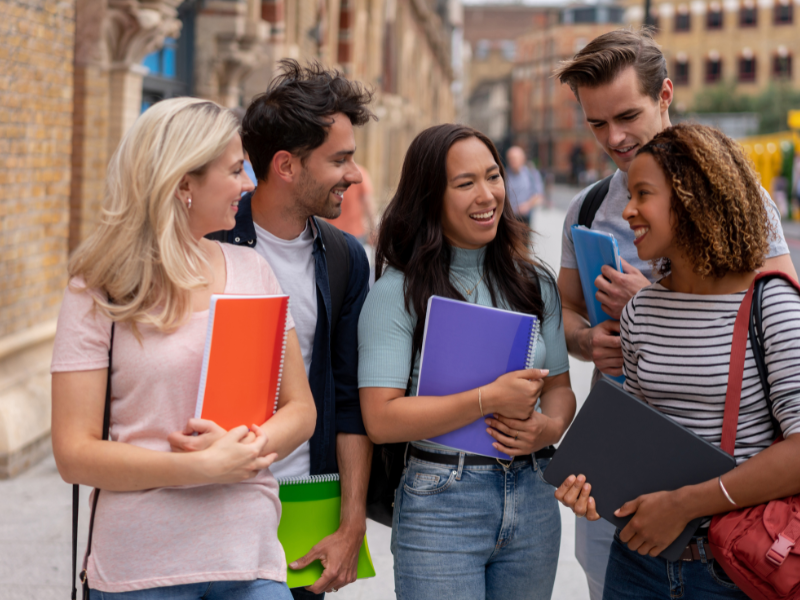 Students chatting outside and carrying school books