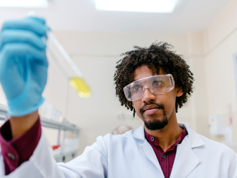 A man holds up a test tube in a lab