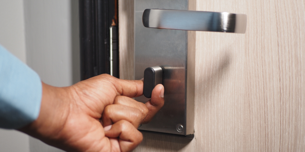 A hand locks a hotel door
