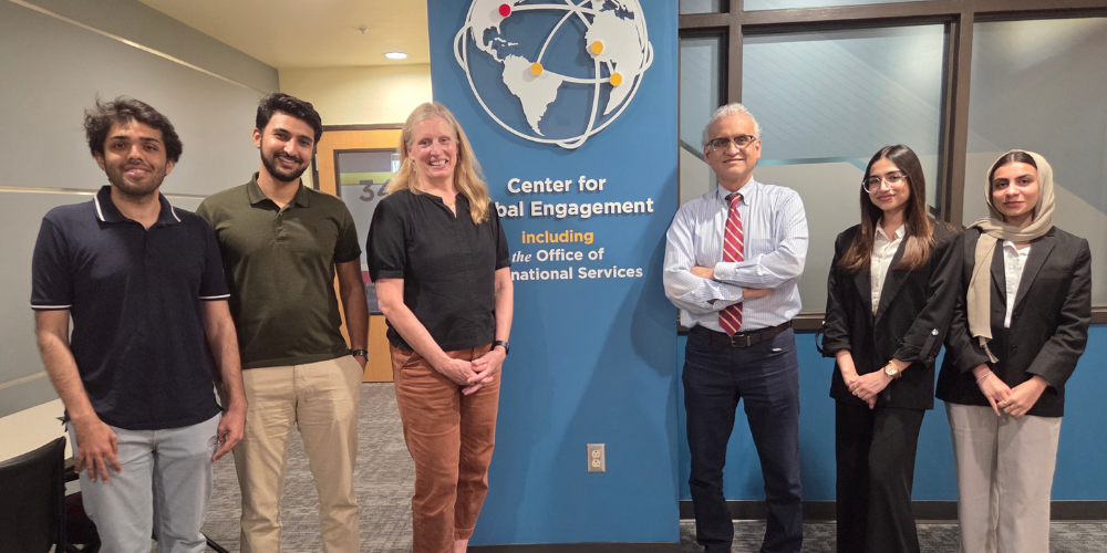 Four students stand with Virginia Rowthorn and Dr. Muhammad Mohiuddin in front of the CGE offices