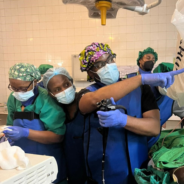 A doctor points to a screen while nurses work behind him.