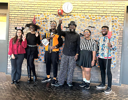 UMB students in Halloween costumes pose for a group photo