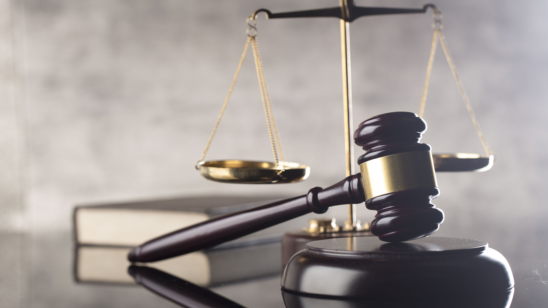 A judges gavel, weight scales, and a law book