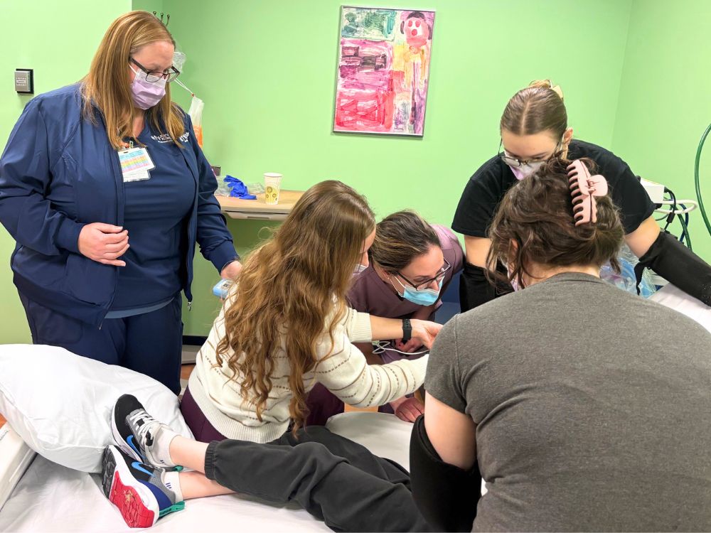 UMSOD’s Erica Caffrey (center) performs a dental exam on a patient at Kennedy Krieger.