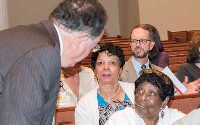 University of Maryland, Baltimore President Jay A. Perman, MD, visits with community members at a town hall meeting of The Partnership for West Baltimore held May 4 at Carter Memorial Church of God In Christ.