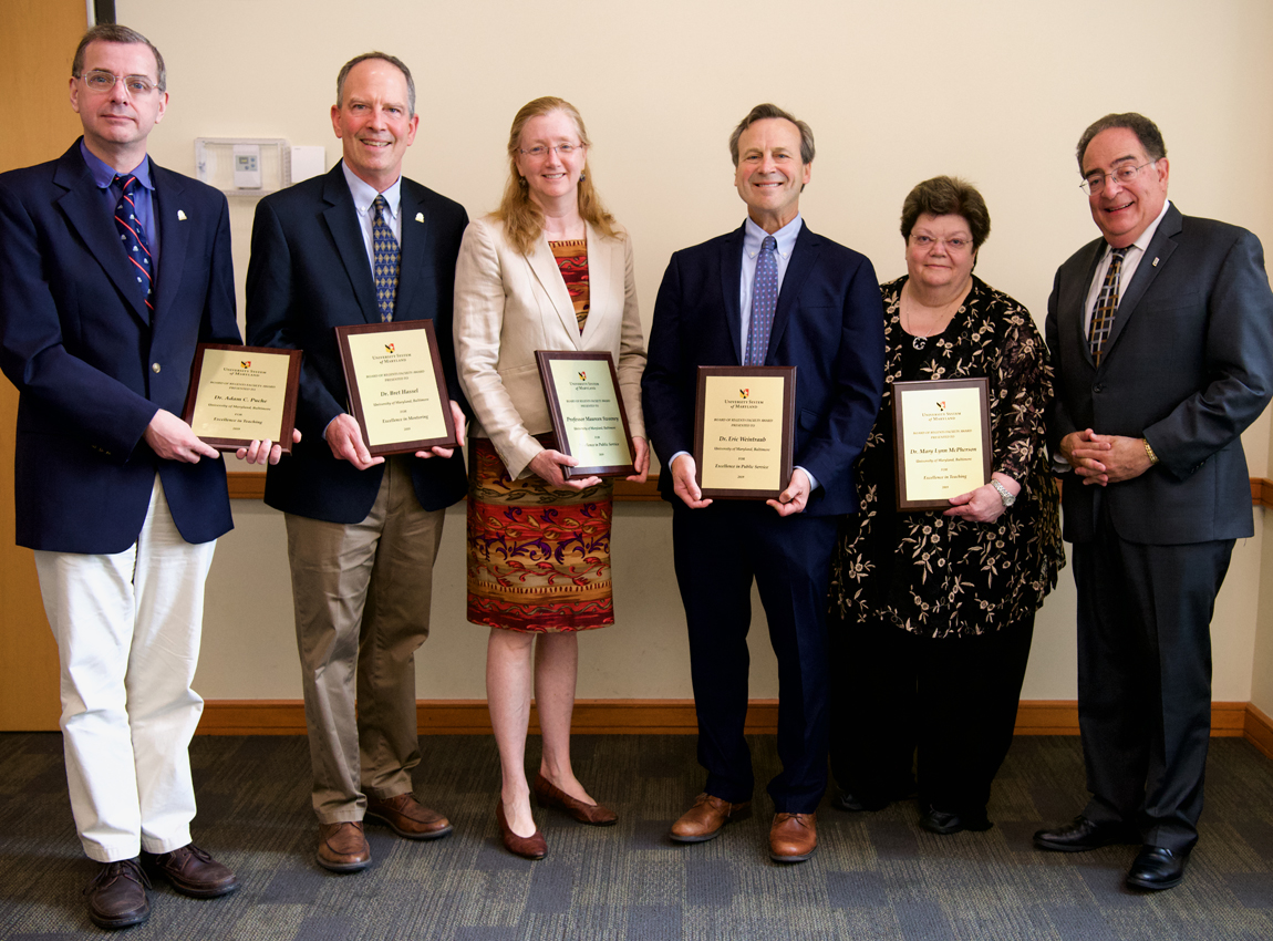 L-to-r, Adam C. Puche, PhD, professor, and Bret Hassel, PhD, associate professor, UM School of Medicine (UMSOM), Maureen Sweeney, JD, associate professor, UM Carey Law; Eric Weintraub, MD, associate professor, UMSOM; Mary Lynn McPherson, PharmD, MA, BCPS, CPE, professor, UM School of Pharmacy; and UMB President Jay A. Perman, MD. UMSOM Sr. Associate Dean Donna Parker, MD, FACP, is not present.