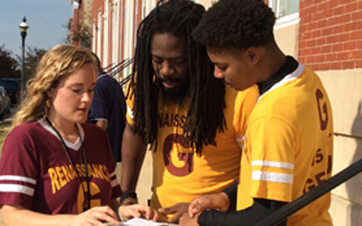 Community schools coordinator Hallie Atwater, LCSW-C, of the University of Maryland School of Social Work; Renaissance Academy mentor Antwon Cooper, and then-senior Khalil Bridges confer outside the high school in November 2015.