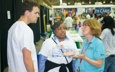 SON student Andrew Frank, left, confers with his instructor, Michelle R. Spencer, MS, RN, of the SON’s Community/Public Health Nursing program, and Liz Ellis, administrative coordinator with the JACQUES Initiative of the SOM's Institute of Human Virology.  