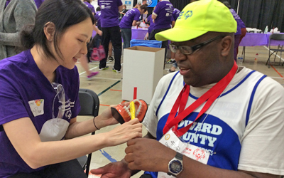 A University of Maryland School of Dentistry student gives oral health tips to an athlete during the Special Smiles clinic at Special Olympics Maryland.