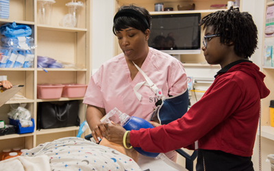 The P-TECH students learn how to intubate and deliver oxygen to a patient from a respiratory therapist at Shock Trauma Center.