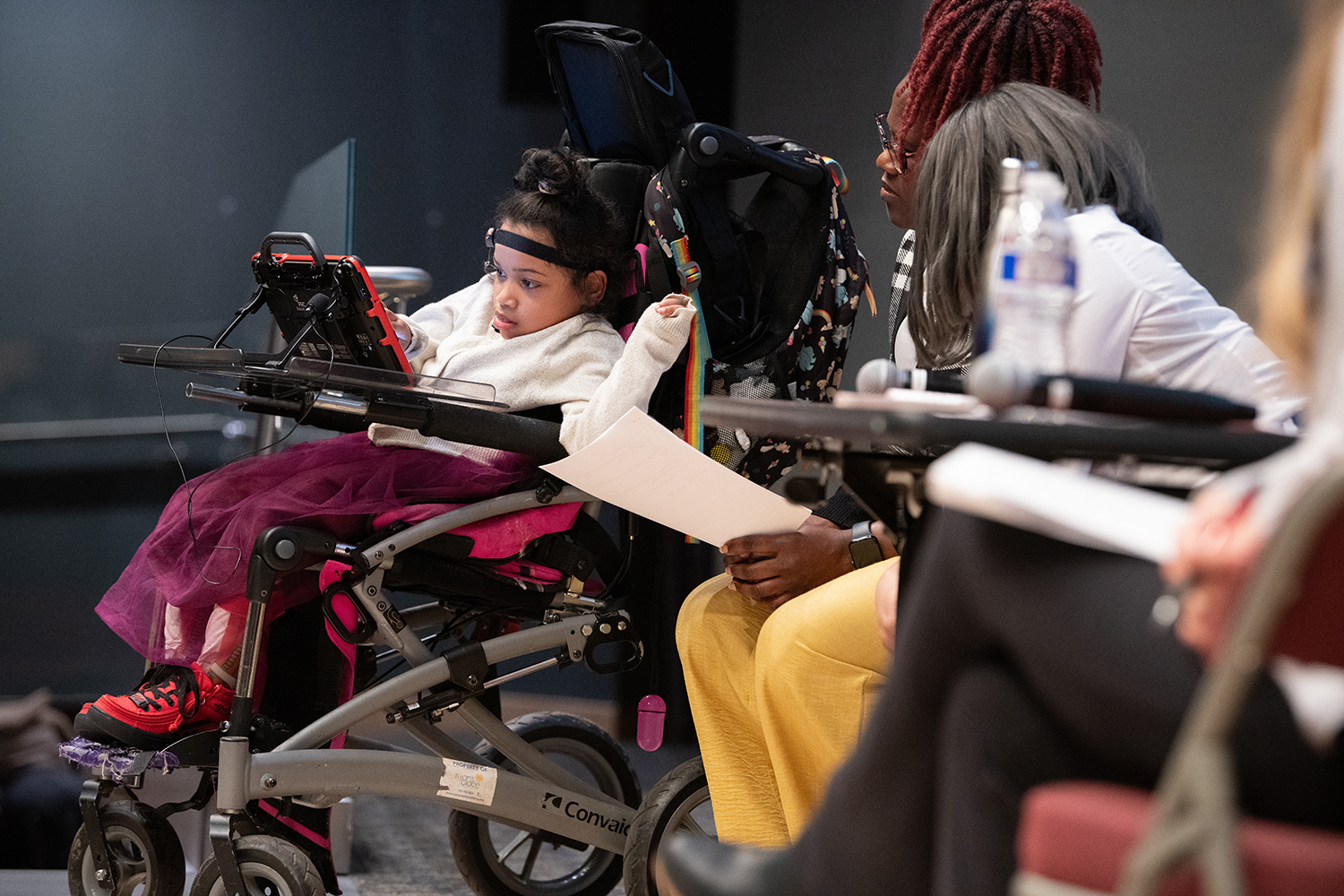 Izzy, whose care was the center of this year’s case study, uses her assistive technology to communicate during the event’s interprofessional patient experience panel.