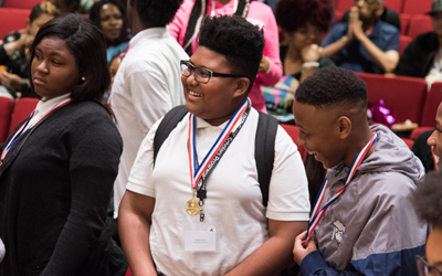 The CURE Scholars stand to be recognized at the 2019 End of the Year Ceremony.