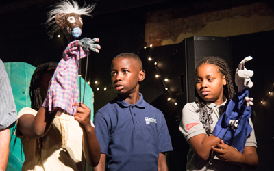 The PAL kids practice the curtain call of their puppet show ahead of their performance at the Black Cherry Puppet Theater.