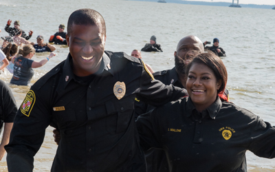 Pfc. Edouardo Edouazin (left) and police communications operator Erika Malone (right) rush out of the freezing Chesapeake Bay after jumping in the water for the annual Polar Bear Plunge.