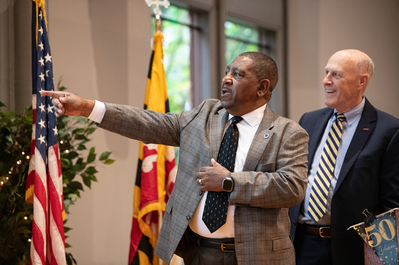 Former chief Cleveland Barnes and current UMB President Bruce Jarrell look at historic photos during the ceremony